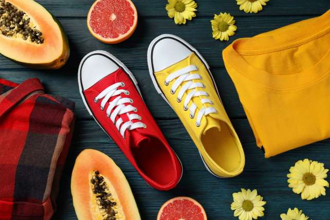 Summer clothes concept with sneakers on wooden background